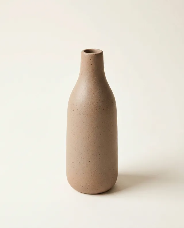 Un vase bouteille élancé à l'émail mat couleur argile.