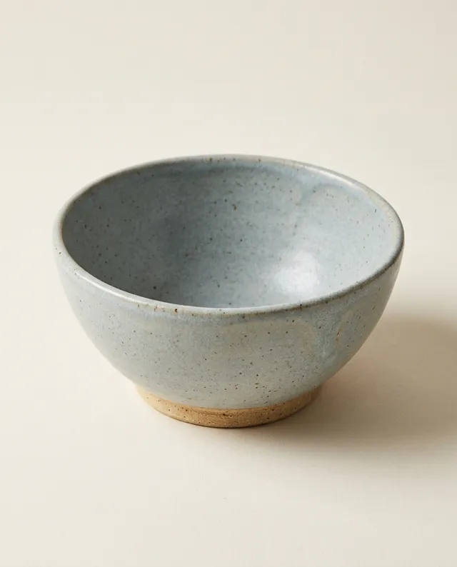 Un bol profond à l'émail gris-bleu, au pied laissé en grès nu.